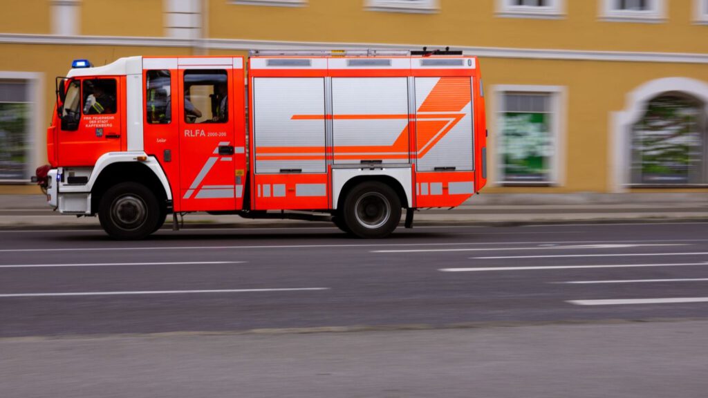 Rotes Feuerwehrfahrzeug fährt durch eine Straße in Kapfenberg