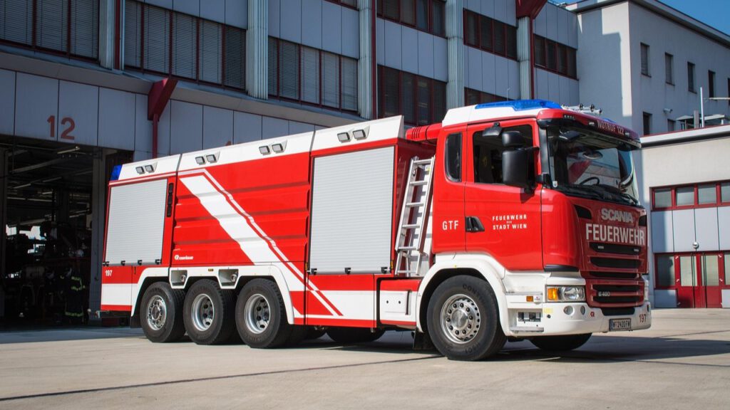 Rot-weißes Großtankfahrzeug der Feuerwehr Wien vor einer Feuerwache