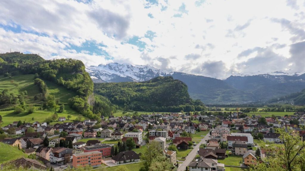 Ortschaft im Rheintal in Liechtenstein vor schneebedeckten Bergen