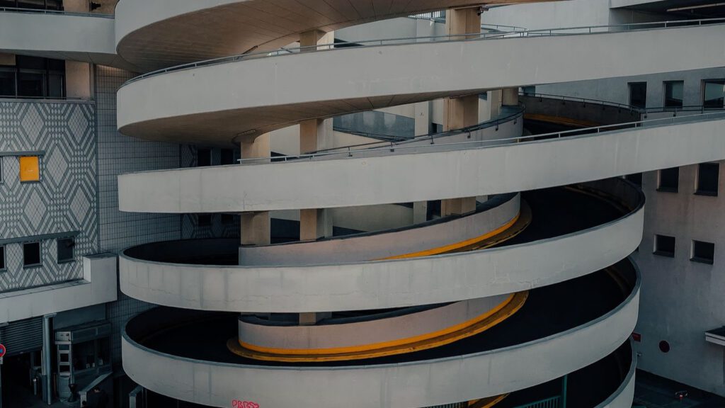 Spiralförmige Auffahrt eines mehrstöckigen Parkhauses in der Dämmerung