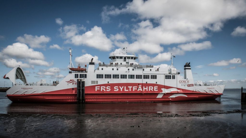 Rot-weiße RoRo-Fähre mit hochgeklapptem Bugvisier im Hafen von Rømø