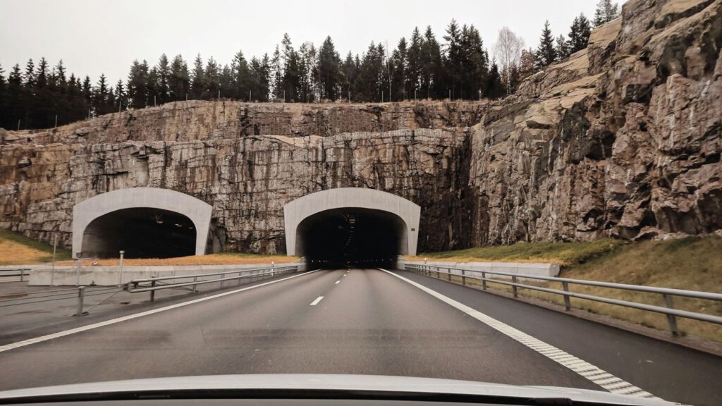 Autobahn führt in zwei Tunnelröhren in einer Felswand